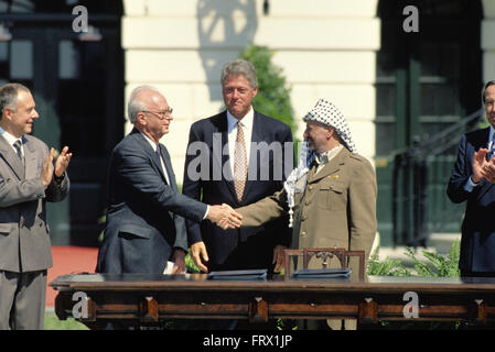 Washington, DC, USA, 13. September 1993 Präsident William Jefferson Clinton beherbergt die palästinensischen Friedensvereinbarungen Vertrags Unterzeichnung auf dem South Lawn des weißen Hauses. Premierminister Yitzhak Rabin Israels und der Palästinensischen Befreiungsorganisation Vorsitzende, Yasser Arafat, die Hand in einer öffentlichen Zeremonie im Weißen Haus nach Unterzeichnung einer Vereinbarung, die gewährt Autonomie nach Palästina begrenzte und den Grundstein für zukünftige Friedensverhandlungen legte. Bildnachweis: Mark Reinstein Stockfoto