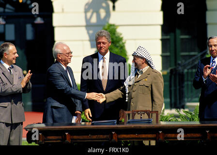 Washington, DC, USA, 13. September 1993 Präsident William Jefferson Clinton beherbergt die palästinensischen Friedensvereinbarungen Vertrags Unterzeichnung auf dem South Lawn des weißen Hauses. Premierminister Yitzhak Rabin Israels und der Palästinensischen Befreiungsorganisation Vorsitzende, Yasser Arafat, die Hand in einer öffentlichen Zeremonie im Weißen Haus nach Unterzeichnung einer Vereinbarung, die gewährt Autonomie nach Palästina begrenzte und den Grundstein für zukünftige Friedensverhandlungen legte. Bildnachweis: Mark Reinstein Stockfoto