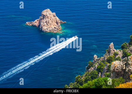 Schnell Motorboot geht zwischen den Steinen des Capo Rosso, Piana Region, Süd-Korsika, Frankreich Stockfoto