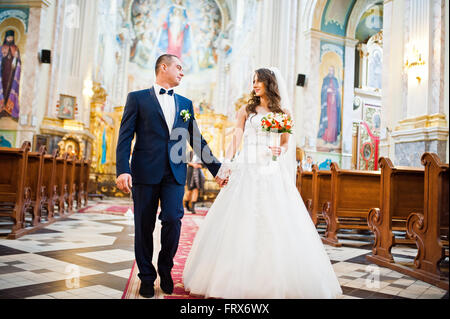 Hochzeitspaar glücklich gehen von der Kirche Stockfoto