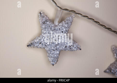 Eine einzelne Perlen Sterne Dekoration hängen an der Wand, eine Weihnachts-Dekoration. Stockfoto