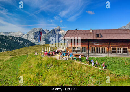 Wanderer verlassen Alphütte vor Hundstod, Gotzenalm, Nationalpark Berchtesgaden, Berchtesgadener Alpen, Upper Bavaria, Bavaria, Germany Stockfoto