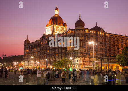 Menschen auf Wellington Pier und das Taj Mahal Palace Hotel bei Dämmerung, Mumbai, Maharashtra, Indien Stockfoto