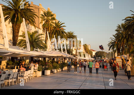 Leute sitzen in Straßencafés entlang der Riva Strandpromenade promenade, Split, Split-Dalmatien, Kroatien Stockfoto