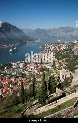 Steilen Fußweg zur Festung und Blick über Altstadt und Kreuzfahrtschiffe Seven Seas Voyager, Regent Kreuzfahrten und MS Deutschland, Reederei Peter Deilmann in Kotor Fjord, Kotor, Montenegro Stockfoto