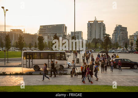 Fußgängern und Verkehr in der Nähe von Skanderbeg-Platz bei Sonnenuntergang, Tirana, Albanien Stockfoto