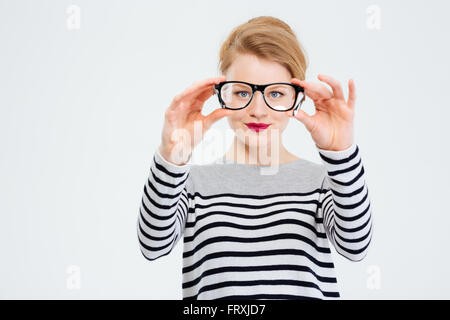 Junge Frau, Blick in die Kamera durch eine Brille, die isoliert auf weißem Hintergrund Stockfoto