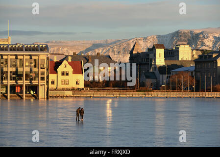 Blick über See Tjörnin mit Rathaus, Reykjavik in Island winter Stockfoto