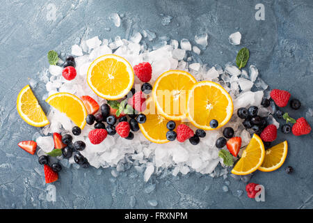 Orangen und Beeren auf Eis Stockfoto