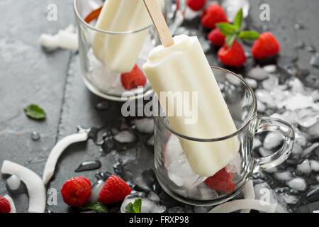 Kokosnuss-Eis mit Himbeeren auf schwarzem Hintergrund Stockfoto