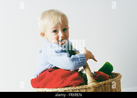 Portrait eines einjährigen jungen sitzen in einem Korb Stockfoto