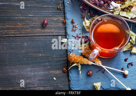 Roter Tee mit Hibiskus und Hagebutte, brauner Zucker Rock Bonbons und getrockneten Tee Blätter Stockfoto