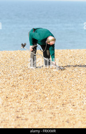 Senior woman Metalldetektoren auf Brighton Beach, East Sussex, England, UK Stockfoto