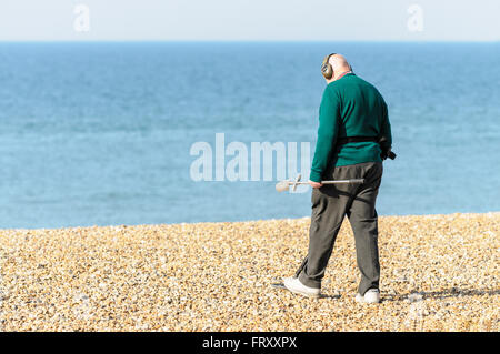 Senior woman Metalldetektoren auf Brighton Beach, East Sussex, England, UK Stockfoto