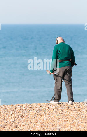 Senior woman Metalldetektoren auf Brighton Beach, East Sussex, England, UK Stockfoto