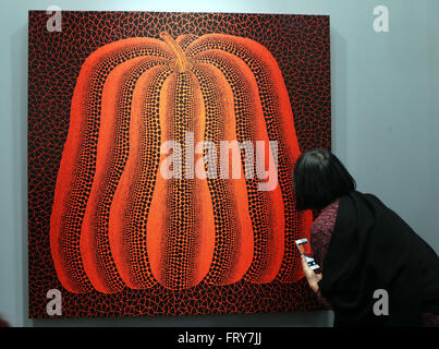 Hong Kong, China. 24. März 2016. Ein Besucher schaut eine Kreation von Yayoi Kusama auf der Art Basel in Hongkong, Südchina, 24. März 2016. Insgesamt 239 Galerien aus 35 Ländern und Regionen besucht die 3-Tages-Art Basel in Hongkong in diesem Jahr. Bildnachweis: Li Peng/Xinhua/Alamy Live-Nachrichten Stockfoto