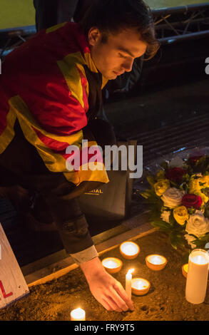 Trafalgar Square, London, März 24. 2016. Ein Mann stellen eine Kerze vor einer riesigen belgische Flagge als Menschen versammeln sich in Angriffe Londoner Trafalgar Square, Kerzen und Blumen im Gedenken an diejenigen, die ihr Leben im Brüsseler Terror verloren lag am 22. März in denen 31 Menschen getötet und Dutzende verletzt. Bildnachweis: Paul Davey/Alamy Live-Nachrichten Stockfoto