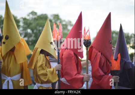 Gekleidet als mit Kapuze Farricocos Kinder nehmen an einer religiösen Prozession, bekannt als die Prozession Fackeln in der Karwoche 23. März 2016 in Goias, Brasilien. Die Prozession symbolisiert die Suche und die Verhaftung von Christus und die Farricocos stellen die römischen Soldaten. Stockfoto