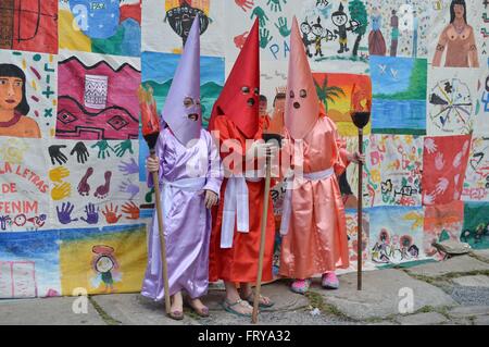 Gekleidet als mit Kapuze Farricocos Kinder nehmen an einer religiösen Prozession, bekannt als die Prozession Fackeln in der Karwoche 23. März 2016 in Goias, Brasilien. Die Prozession symbolisiert die Suche und die Verhaftung von Christus und die Farricocos stellen die römischen Soldaten. Stockfoto