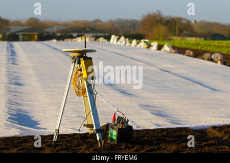 Externer GPS-Empfänger im Burscough, Lancashire, Großbritannien, 25. März 2016 verwendet. UK Wetter. Eine Landschaft, die in weißem Vlies abgedeckt, da die Landwirte Trimble GPS-Traktor-Leitsysteme Ausrüstung verwenden, um ihre Felder zu Handlung und Werk und salatpflänzlinge dieser Jahreszeiten'. Gartenbau Fleece ist ein dünnes, Ungewebte, Polypropylen Gewebe, das wie eine schwebende Mulch sowohl frühe und späte Ernte und andere empfindliche Pflanzen vor Kälte und Frost, sowie Insekten während der normalen Vegetationsperiode zu schützen, verwendet wird. Stockfoto