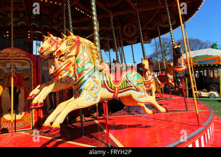 Southend on Sea, Großbritannien. März 2016. Ein farbenfrohes Karussell mit aufwändig bemalten Pferden mit dekorativen Sätteln und Trensen vor festlicher Kulisse. Das Baldachin ist mit Lichtern und kunstvollen Mustern geschmückt, die den skurrilen Geist traditioneller britischer Vergnügungen einfangen. Carter's Steam Fair ist für die Osterferien in Southend. Die berühmte Vintage-Vergnügungsmesse mit einer Reihe wunderschön restaurierter Fahrgeschäfte. Quelle: Penelope Barritt/Alamy Live News Stockfoto