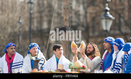 Trafalgar Square, London, UK. 25. März 2016. Am Karfreitag Ostern durchgeführt die Wintershall-Besetzung der "Passion" und die Auferstehung Jesu Christi mit Trafalgar Square als Bühne. Schauspieler James Burke-Dunsmore als Jesus bricht beim letzten Abendmahl Brot. Copyright Carol Moir/Alamy Live News Stockfoto