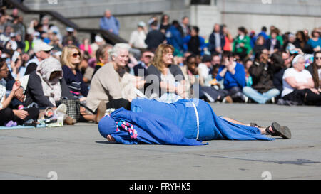 Trafalgar Square, London, UK. 25. März 2016. Am Karfreitag Ostern durchgeführt die Wintershall-Besetzung der "Passion" und die Auferstehung Jesu Christi mit Trafalgar Square als Bühne. Ein Schüler schläft vor dem Publikum. Copyright Carol Moir/Alamy Live News Stockfoto