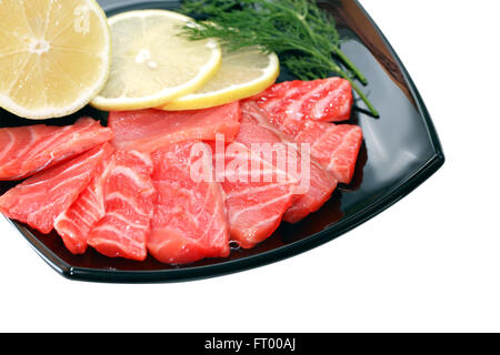 Scheiben Gesalzener Lachs mit Zitrone auf schwarzen Druckplatte. Isoliert mit Beschneidungspfad Stockfoto