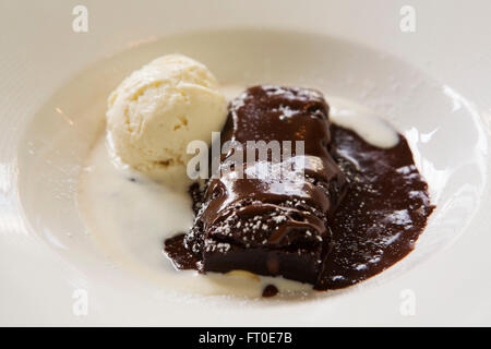 Schokoladen-Brownie mit Vanille-Eis in London, England serviert. Stockfoto