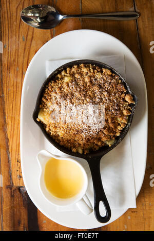 Apfelkuchen serviert mit einem Topf Creme in London, England. Stockfoto