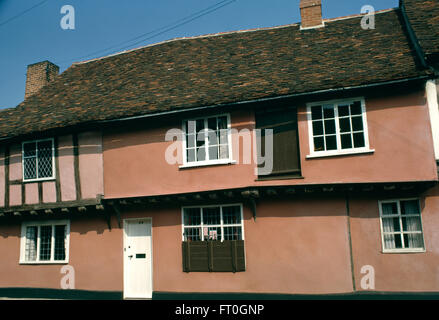 Eine traditionelle rosa lackierten Suffolk Haus mit einer weißen Fronttür und halbe Holzklappläden in einem Fenster Stockfoto