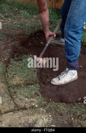 Nahaufnahme eines Gärtners umgraben Rasen vor der Verlegung Pflaster Stockfoto