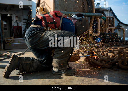 Seaman Conor Magill, eine Boje Deck Crewmitglied an Bord der Coast Guard Cutter Katherine Walker, schneidet die Kette mit einer Fackel an Bord der Coast Guard Cutter Katherine Walker beim Transit durch den Hafen von New York, 8. März 2016. Katherine Walkers primäre Aufgabe ist die Aufrechterhaltung über 300 schwimmende Hilfsmittel zur Navigation in und um New York Hafen und seine Ansätze, Long Island Sound, Hudson und East River und anderen Gewässern entlang der Küste von Connecticut, New York und New Jersey. (Foto: U.S. Coast Guard Petty Officer 3rd Class Frank Iannazzo-Simmons) Stockfoto