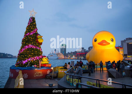 Weihnachtsbaum und riesige Gummiente schwimmende Skulptur, entworfen vom holländischen Künstler Florentijn Hofman, im Hafen in der Abenddämmerung, Keelung, Norden von Taiwan, Taiwan Stockfoto