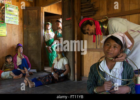 Longneck-Karen-Frauen tragen typische Halsketten, in der Nähe von dreizehn Jahre alten Schulmädchen bekommen eine Kette zum ersten Mal Padaung Frauen Loikaw, Kayah-Staat, Karenni State in Myanmar, Myanmar, Asien Stockfoto