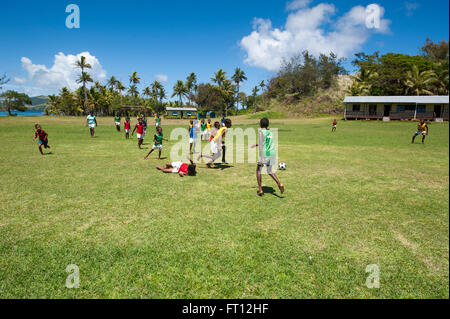 Dorf Jungs spielen Fußball auf einem Feld, Palmen in der Ferne, Sawa-i-Lau Insel Yasawa Inseln, Fidschi, Südpazifik Stockfoto