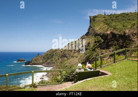 Ein paar auf einer Bank sitzen und bewundern Sie die Küste, Pitcairn, Pitcairn Group of Islands, British Overseas Territory, South Pacific Stockfoto
