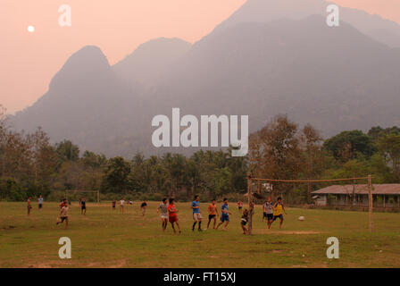 Jungs spielen Fußball, Berge im Hintergrund Stockfoto