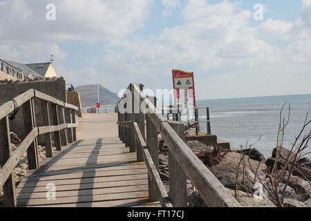 Holzbrücke mit roten Warnschild, Klippen und Meer Stockfoto