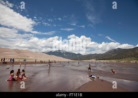 Ein Blick-Touristen im Fluss Medano im Great Sand Dunes National Park. Stockfoto