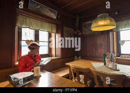 Frau studieren Wanderkarte im traditionellen alpinen Stil Gästezimmer der Meiler Hütte im Wettersteingebirge, Bayern Stockfoto