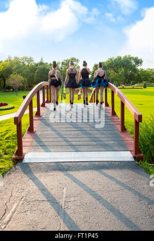 Vier Teenager Ballerinas Fuß nach Hause durch den Park, Tutu und Springerstiefel tragen. Stockfoto