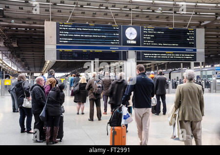 Passagiere warten auf ihren Zügen unter Abfahrtstafeln am Bahnhof St Pancras International in London. Stockfoto