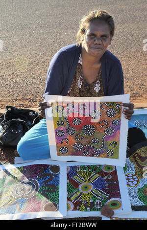 ein Aborigine-Künstler Jean Brumby Anzeigen ihrer Bilder am uluru Stockfoto