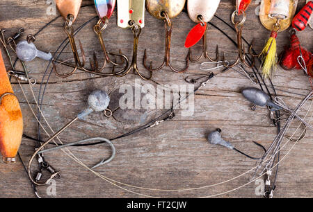 verschiedene Angelgeräte und Löffel auf Holzbrett Hintergrund. Konzeptdesign für Süßwasser im freien aktiven Unternehmen. Stockfoto