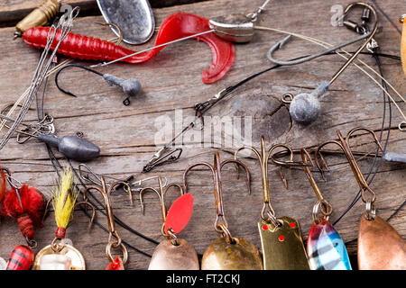 verschiedene Angelgeräte und Löffel auf Holzbrett Hintergrund. Konzeptdesign für Süßwasser im freien aktiven Unternehmen. Stockfoto