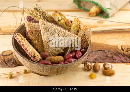 Integrale Kekse mit Mandeln und Hagebutten in einer Kokosnussschale serviert Stockfoto