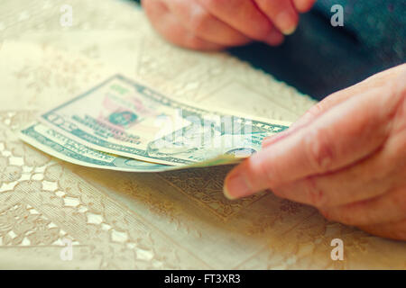 Nahaufnahme der älteren Dame mit Dollar-Scheine in Händen, getönten Bild Instagram-wie Farbe, Tiefenschärfe, sehr flachen DOF Stockfoto
