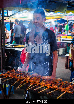 Mann Kochen Hähnchen-Spieße auf dem Grill auf einem traditionellen Nachtmarkt auf der Insel Langkawi, Kedah, Malaysia Stockfoto