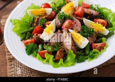 Warmer Salat mit Geflügelleber, grüne Bohnen, Eiern, Tomaten und Balsamico-dressing Stockfoto